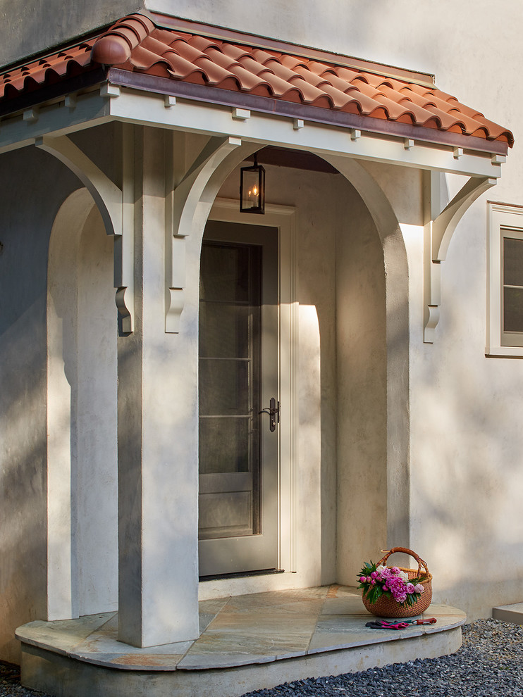 На фото: маленький тамбур в средиземноморском стиле с одностворчатой входной дверью и серой входной дверью для на участке и в саду с