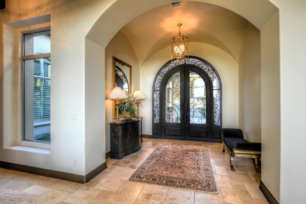 Inspiration for a large mediterranean travertine floor entryway remodel in Austin with beige walls and a metal front door
