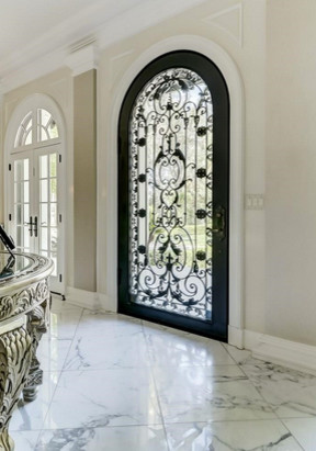 Entryway - huge traditional marble floor entryway idea in Miami with beige walls and a metal front door