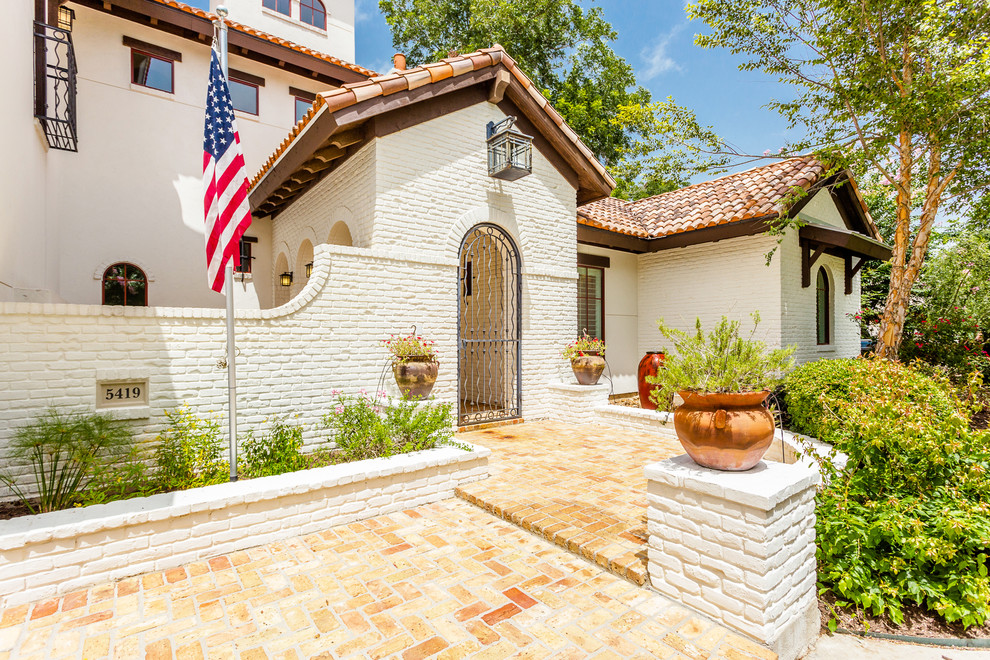 Design ideas for a large mediterranean entrance in Houston with brick flooring and brown floors.
