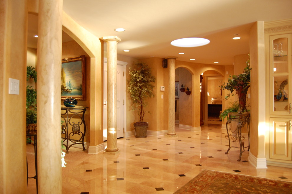 Large mediterranean foyer in Seattle with brown walls, marble flooring and brown floors.