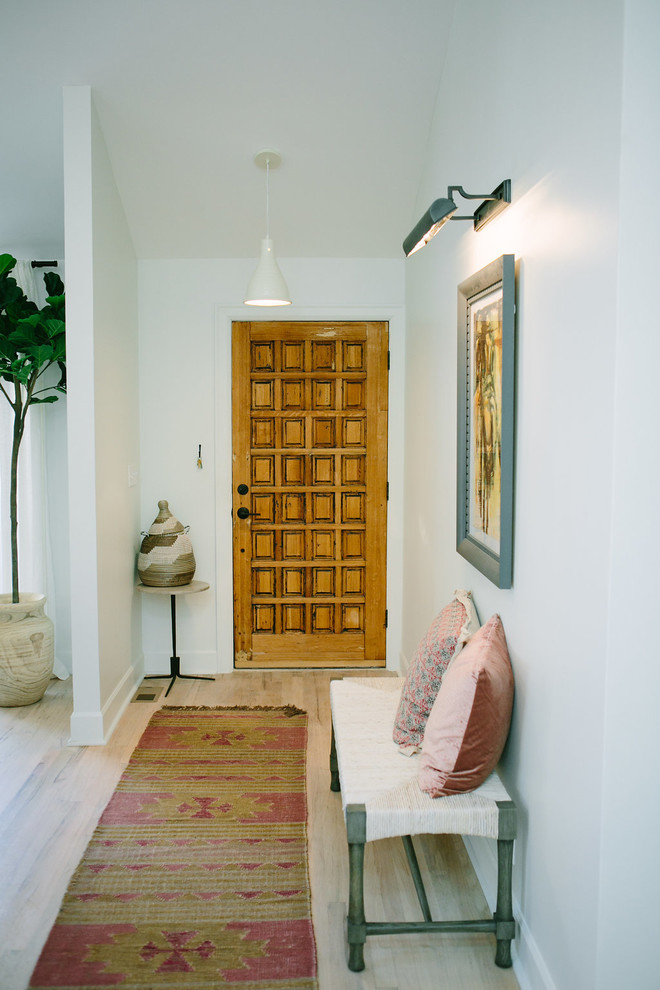 Inspiration for a small limestone floor entryway remodel in Denver with yellow walls and a medium wood front door