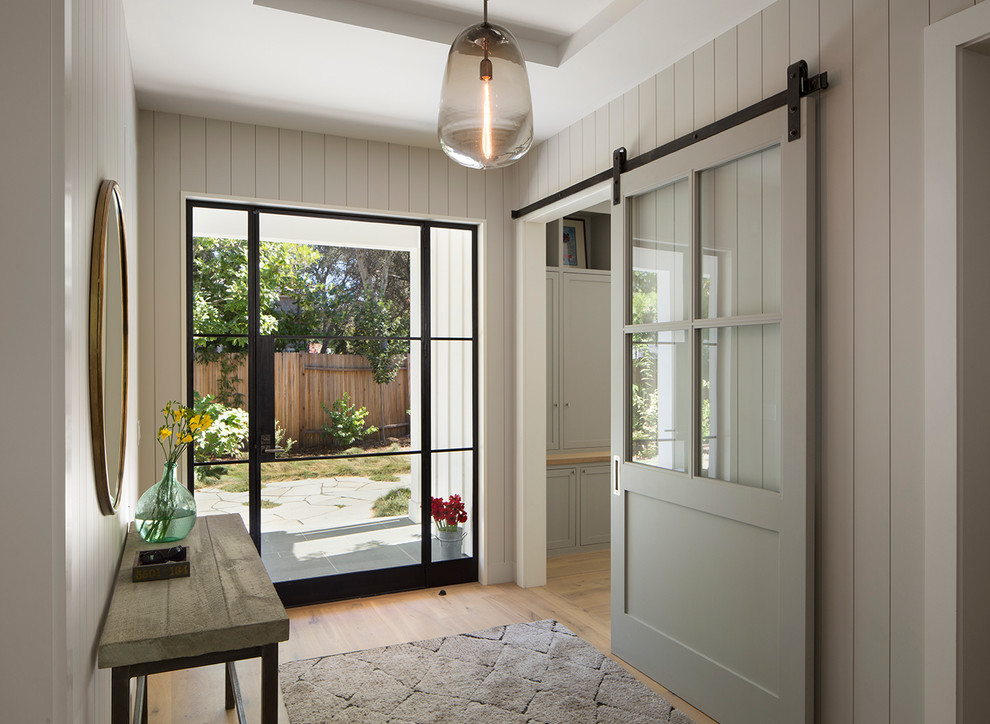 Foto di una grande porta d'ingresso country con parquet chiaro, una porta singola, una porta in vetro e pareti bianche