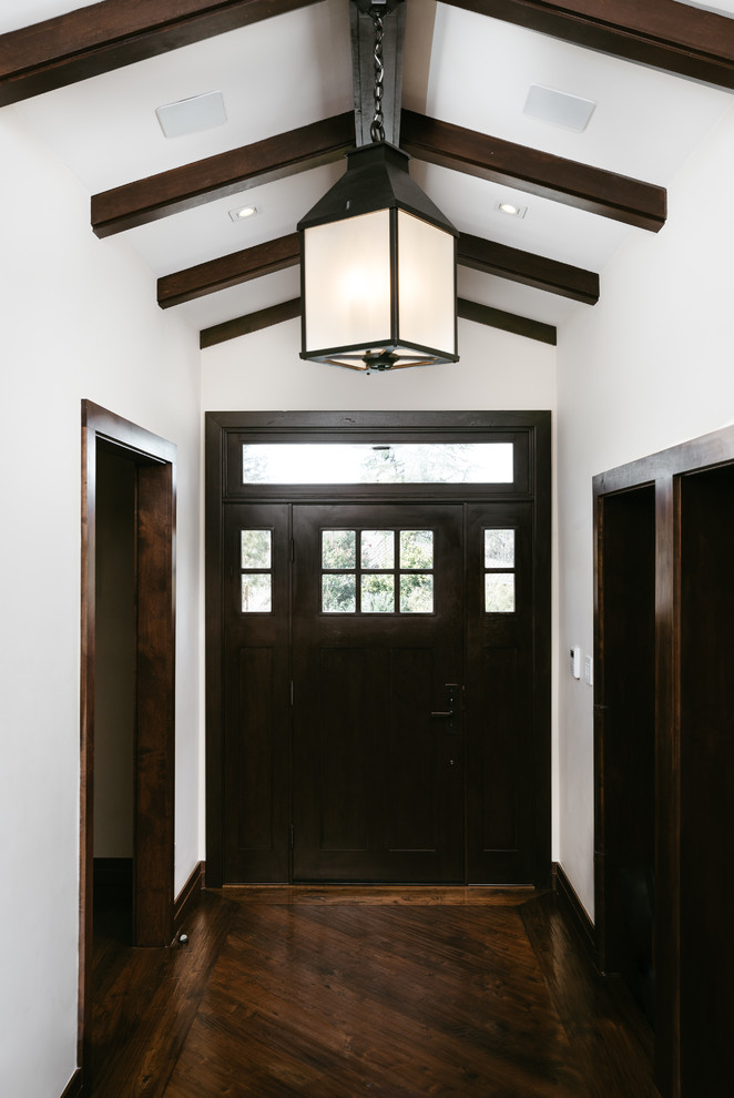 Cette image montre une porte d'entrée craftsman de taille moyenne avec un mur beige, parquet foncé, une porte simple et une porte en bois foncé.