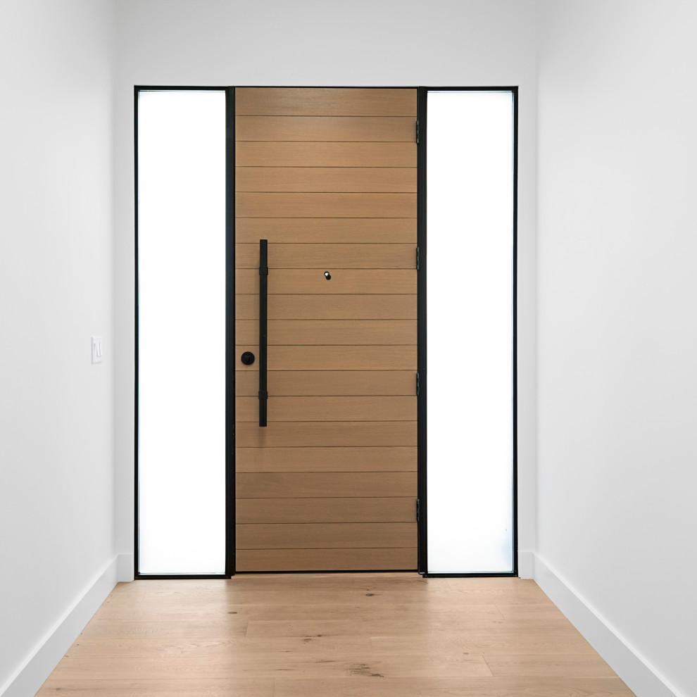 Modelo de puerta principal minimalista de tamaño medio con paredes blancas, suelo de madera clara, puerta simple, puerta de madera clara y suelo marrón