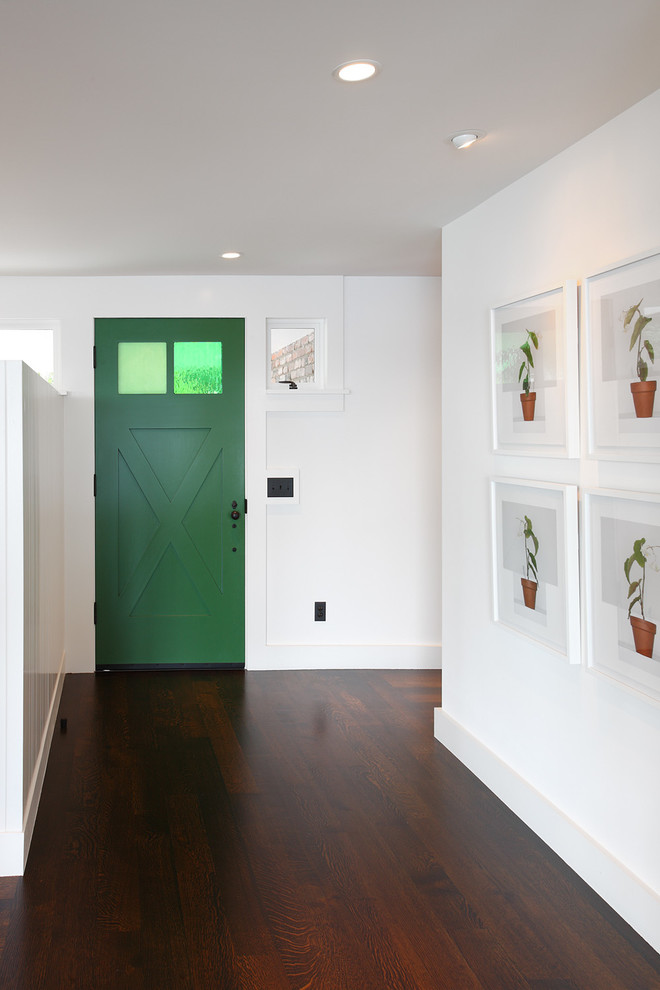 Exempel på en klassisk ingång och ytterdörr, med vita väggar, mörkt trägolv, en enkeldörr och en grön dörr