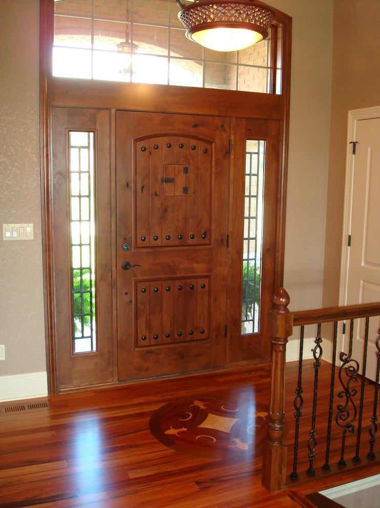 Foto de puerta principal clásica de tamaño medio con paredes beige, suelo de madera en tonos medios, puerta simple y puerta de madera en tonos medios
