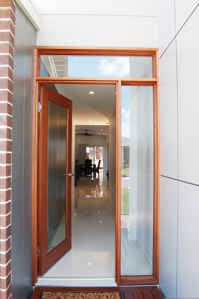 Cette photo montre une petite porte d'entrée tendance avec un mur gris, un sol en bois brun, une porte simple, une porte en bois brun, un plafond voûté et boiseries.