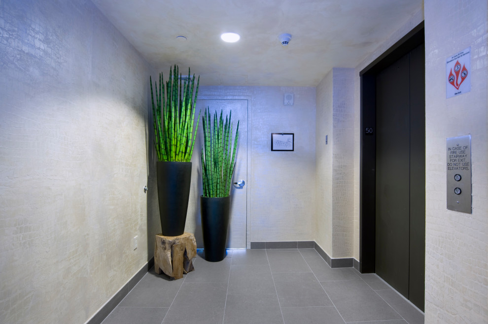 Exemple d'un hall d'entrée moderne de taille moyenne avec un mur beige, un sol en carrelage de porcelaine et un sol gris.