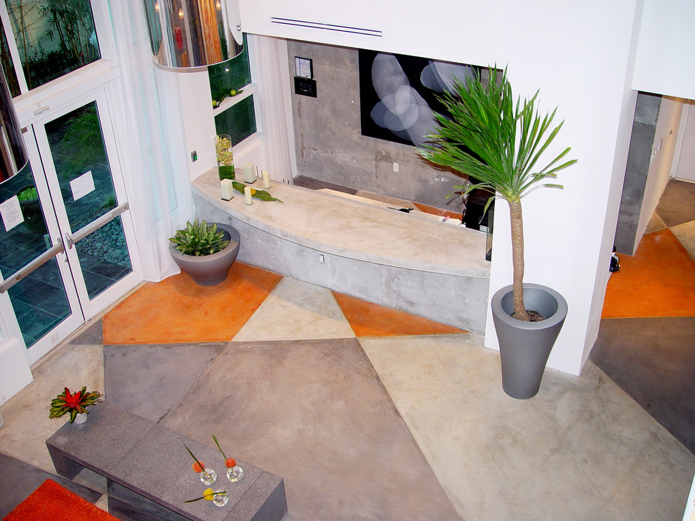 Esempio di un grande corridoio design con pareti grigie, pavimento in cemento, una porta a due ante e una porta in vetro
