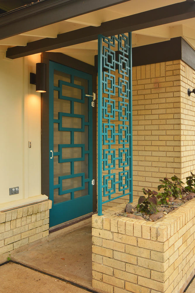На фото: входная дверь среднего размера в стиле модернизм с коричневыми стенами, бетонным полом, одностворчатой входной дверью и синей входной дверью с