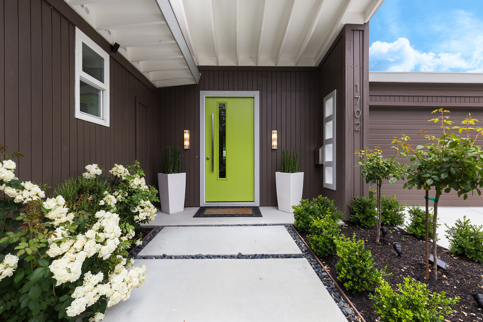 Idee per una porta d'ingresso minimalista con pareti marroni, una porta singola, una porta verde e pavimento giallo