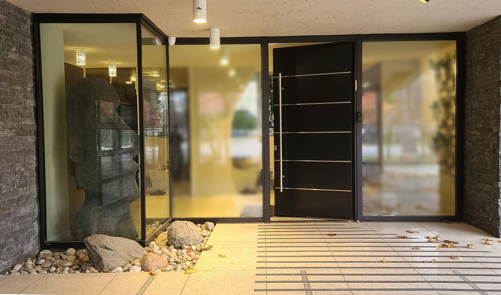 Idées déco pour une porte d'entrée contemporaine avec un mur gris, un sol en travertin, une porte simple, une porte noire et un sol beige.