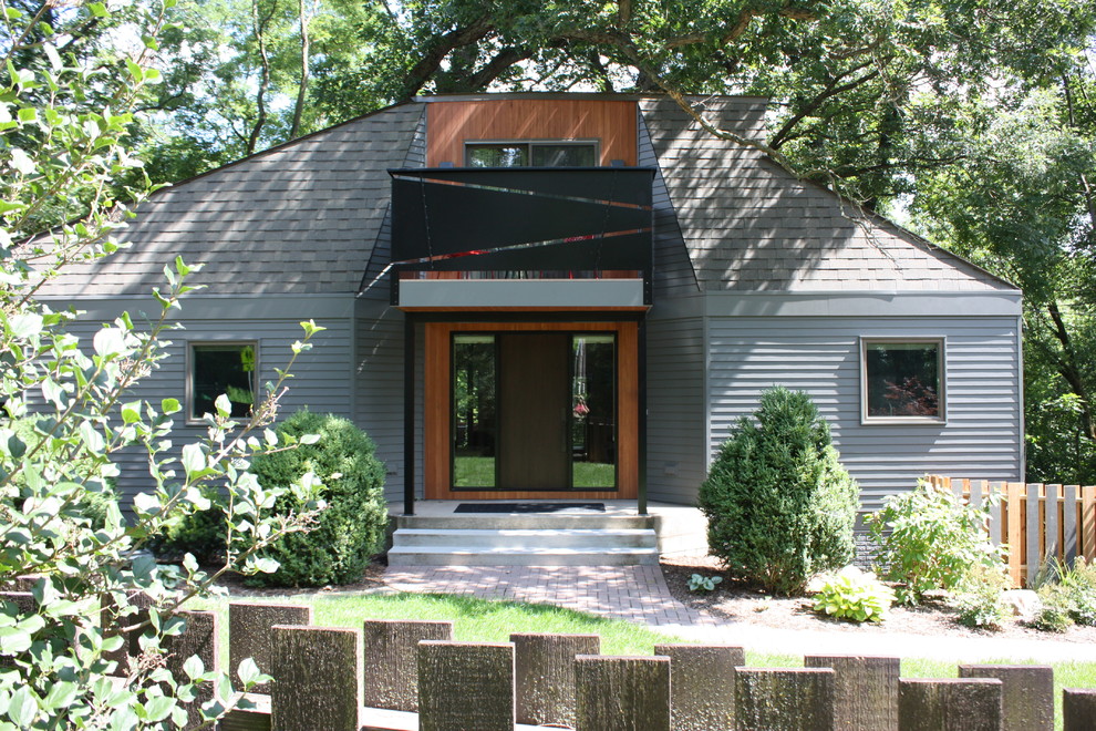 シーダーラピッズにあるラグジュアリーな小さなミッドセンチュリースタイルのおしゃれな玄関ドア (緑の壁、コンクリートの床、木目調のドア、グレーの床) の写真
