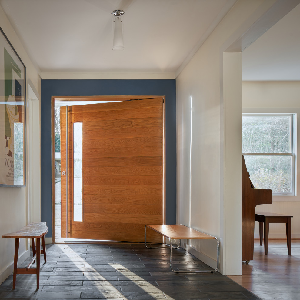 Ispirazione per una porta d'ingresso minimalista di medie dimensioni con pareti bianche, pavimento in ardesia, una porta a pivot, una porta marrone e pavimento grigio