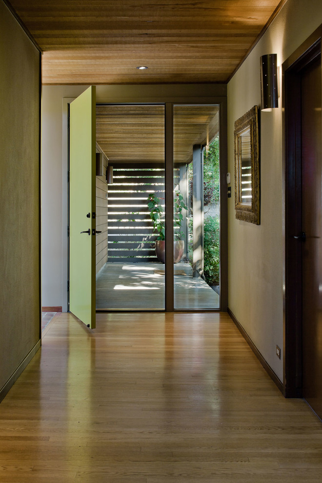 Источник вдохновения для домашнего уюта: большая узкая прихожая в стиле модернизм с бежевыми стенами, светлым паркетным полом, одностворчатой входной дверью, зеленой входной дверью и бежевым полом