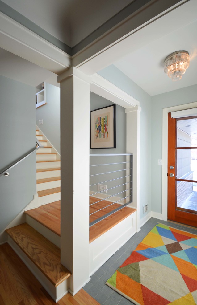 This is an example of a medium sized retro foyer in Minneapolis with green walls, ceramic flooring, a single front door, a medium wood front door and green floors.