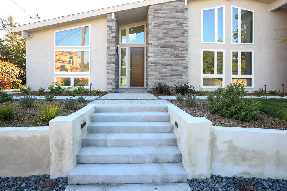 This is an example of a large contemporary front door in San Diego with a single front door and a medium wood front door.