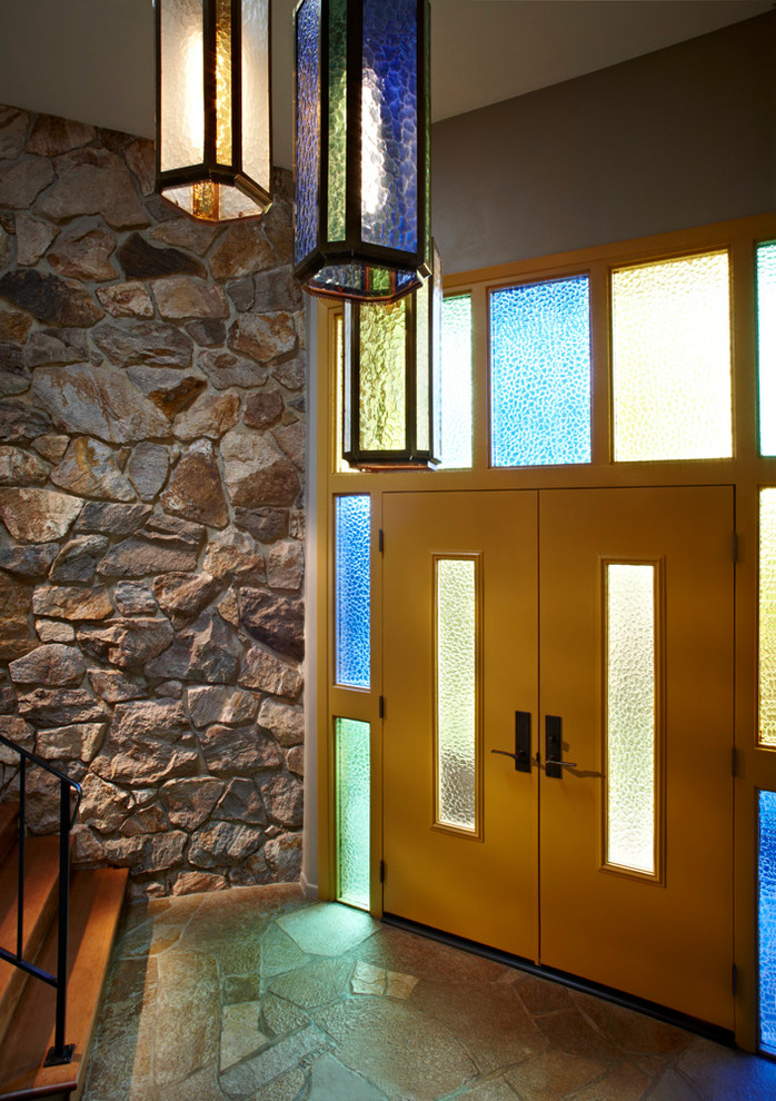 Aménagement d'un très grand hall d'entrée rétro avec un mur gris, une porte double et une porte jaune.