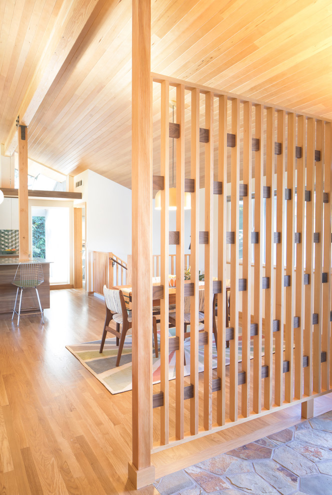 Exemple d'une porte d'entrée rétro de taille moyenne avec un sol en bois brun, une porte simple, une porte bleue et un sol marron.