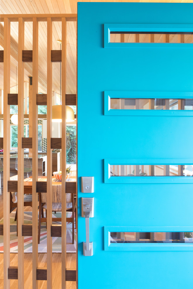 Retro inredning av en mellanstor ingång och ytterdörr, med mellanmörkt trägolv, en enkeldörr, en blå dörr och brunt golv