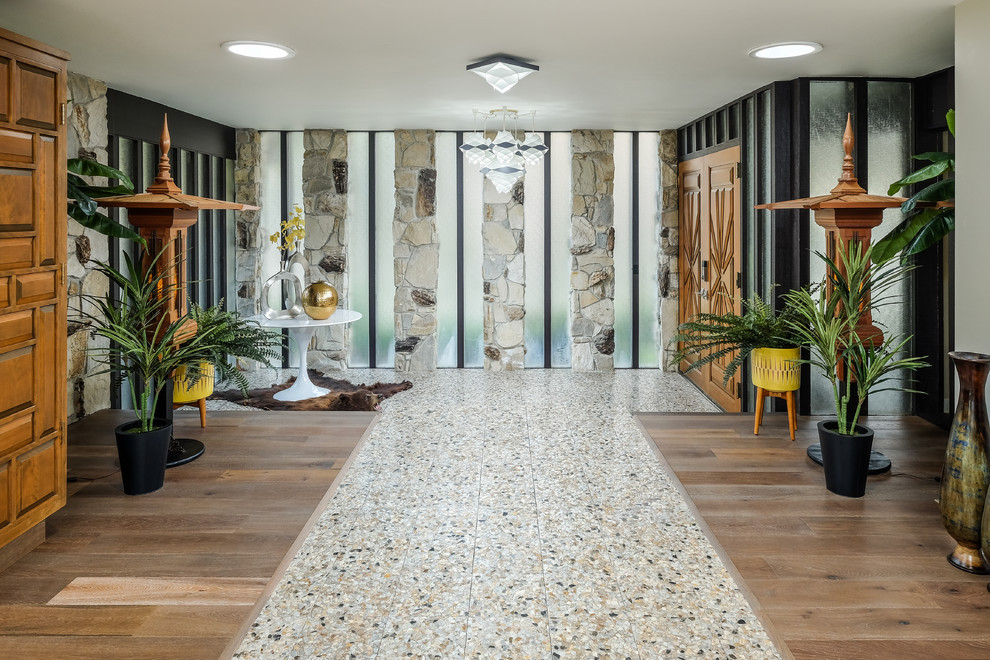 サクラメントにある高級な広いミッドセンチュリースタイルのおしゃれな玄関ロビー (グレーの壁、テラゾーの床、木目調のドア、グレーの床) の写真