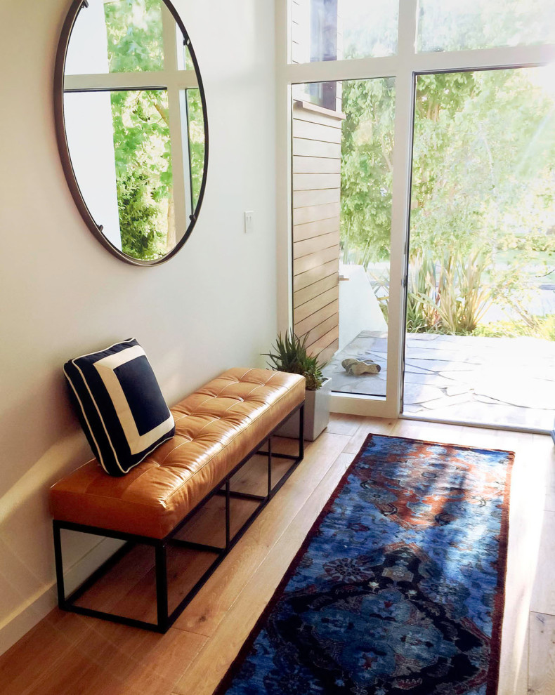 ロサンゼルスにある高級な中くらいなミッドセンチュリースタイルのおしゃれな玄関ロビー (白い壁、淡色無垢フローリング、淡色木目調のドア、茶色い床、表し梁) の写真