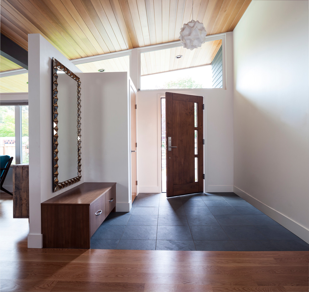 Example of a mid-century modern ceramic tile entryway design in Seattle with white walls and a dark wood front door