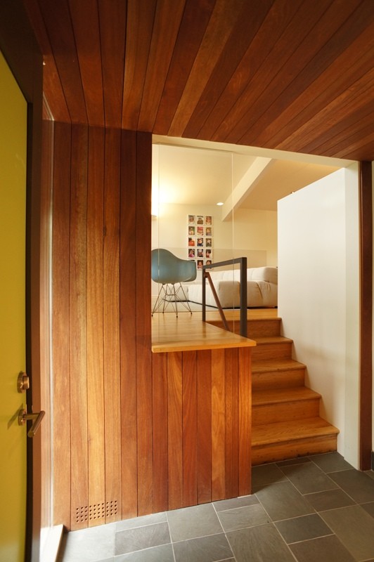 Idéer för en liten modern foajé, med bruna väggar, skiffergolv, en enkeldörr och en gul dörr