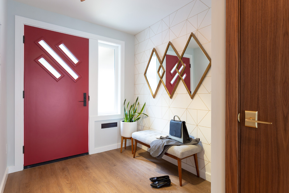 Aménagement d'une petite porte d'entrée rétro avec un mur gris, un sol en bois brun, une porte simple, une porte rouge et un sol marron.