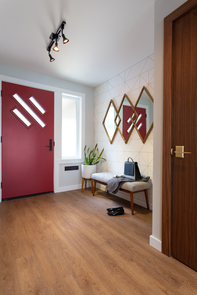 バンクーバーにある小さなミッドセンチュリースタイルのおしゃれな玄関ドア (グレーの壁、無垢フローリング、赤いドア、茶色い床) の写真