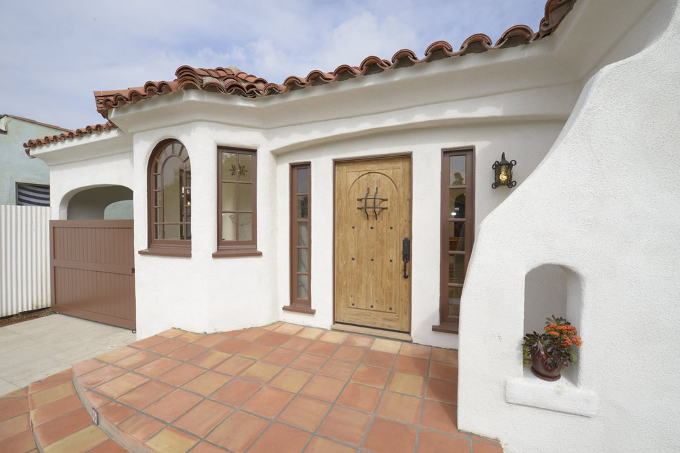 Große Mediterrane Haustür mit weißer Wandfarbe, Terrakottaboden, Einzeltür und heller Holzhaustür in Los Angeles