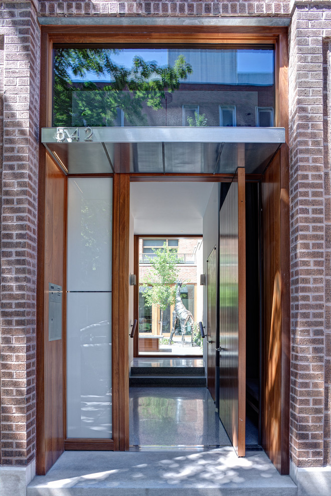 Idee per una porta d'ingresso industriale con una porta a pivot e una porta in legno bruno