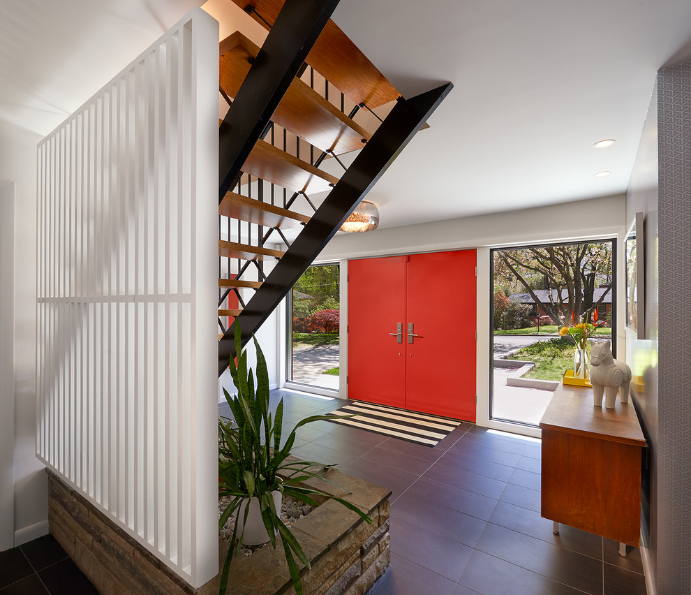 Cette image montre un hall d'entrée vintage avec une porte double et une porte rouge.
