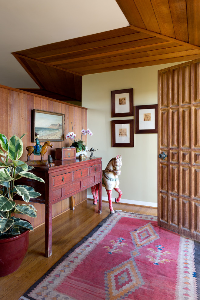 Diseño de entrada retro con paredes beige, suelo de madera en tonos medios, puerta simple y puerta de madera en tonos medios