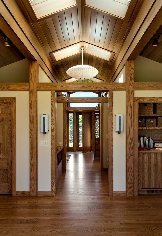 Ejemplo de hall retro con paredes blancas, suelo de madera en tonos medios, puerta simple y puerta de madera en tonos medios