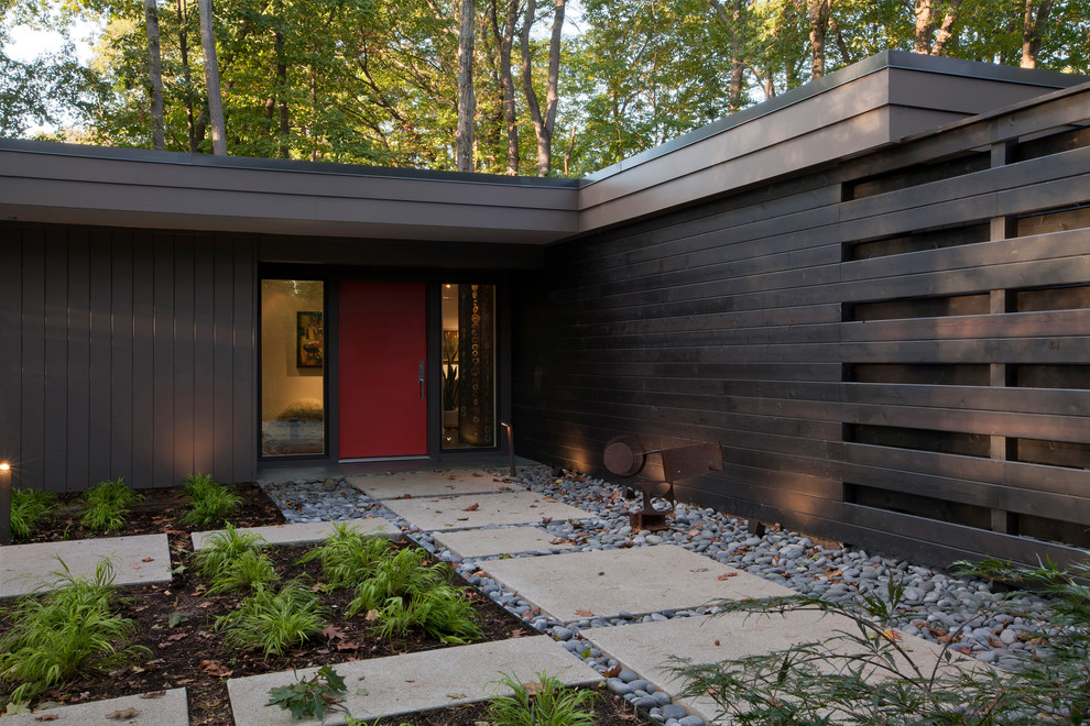 Стильный дизайн: входная дверь среднего размера в стиле ретро с коричневыми стенами, бетонным полом, одностворчатой входной дверью, красной входной дверью и бежевым полом - последний тренд