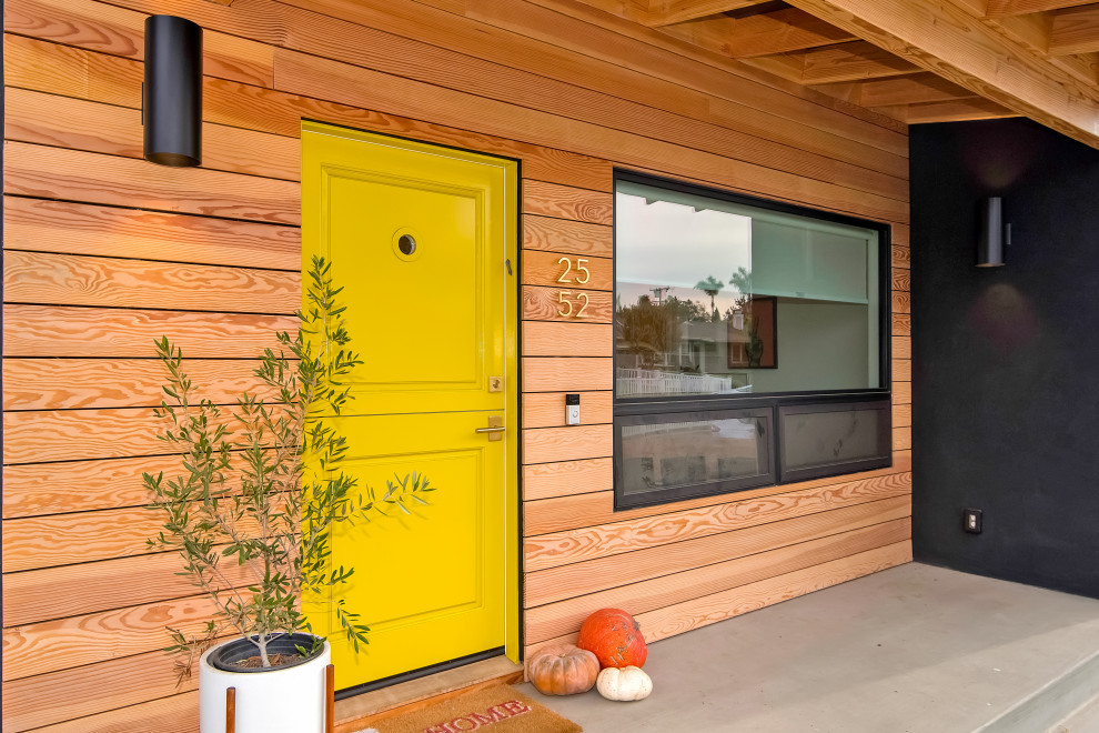 Ispirazione per una porta d'ingresso minimalista di medie dimensioni con pareti nere, una porta olandese e una porta gialla