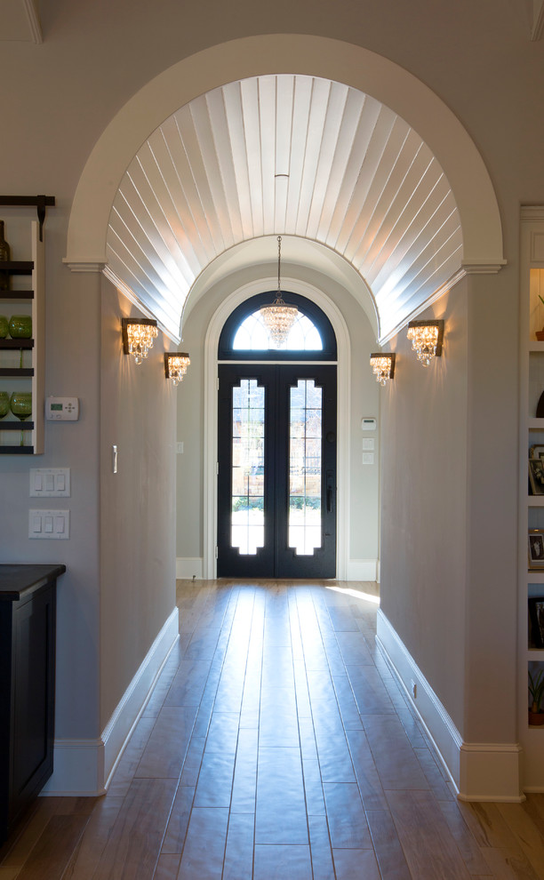 Modelo de hall vintage de tamaño medio con paredes grises, suelo de madera clara, puerta doble y puerta de madera oscura