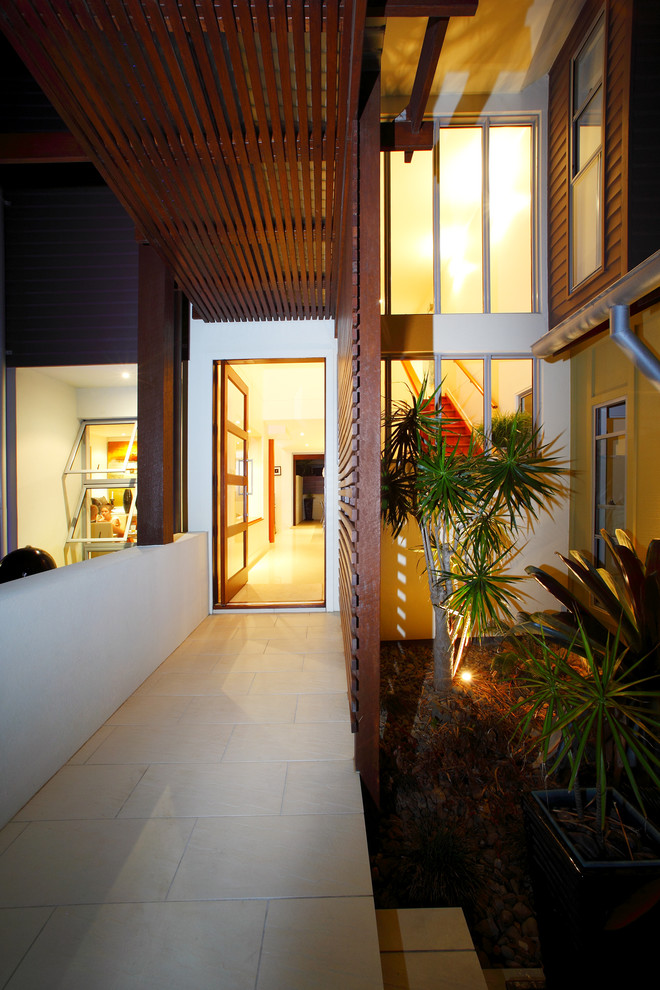 This is an example of a medium sized contemporary foyer in Gold Coast - Tweed with white walls, ceramic flooring, a single front door and a dark wood front door.