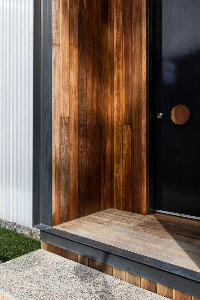 Idee per una porta d'ingresso minimal di medie dimensioni con pareti bianche, parquet scuro, una porta singola e una porta nera