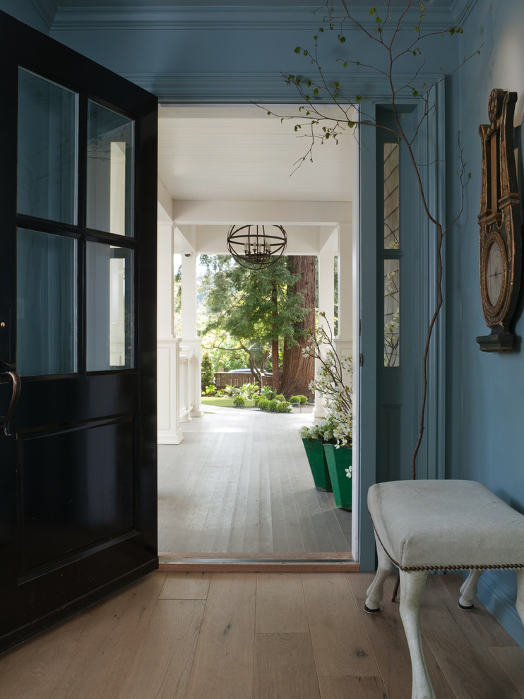 Idéer för att renovera en vintage entré, med en svart dörr, blå väggar och beiget golv