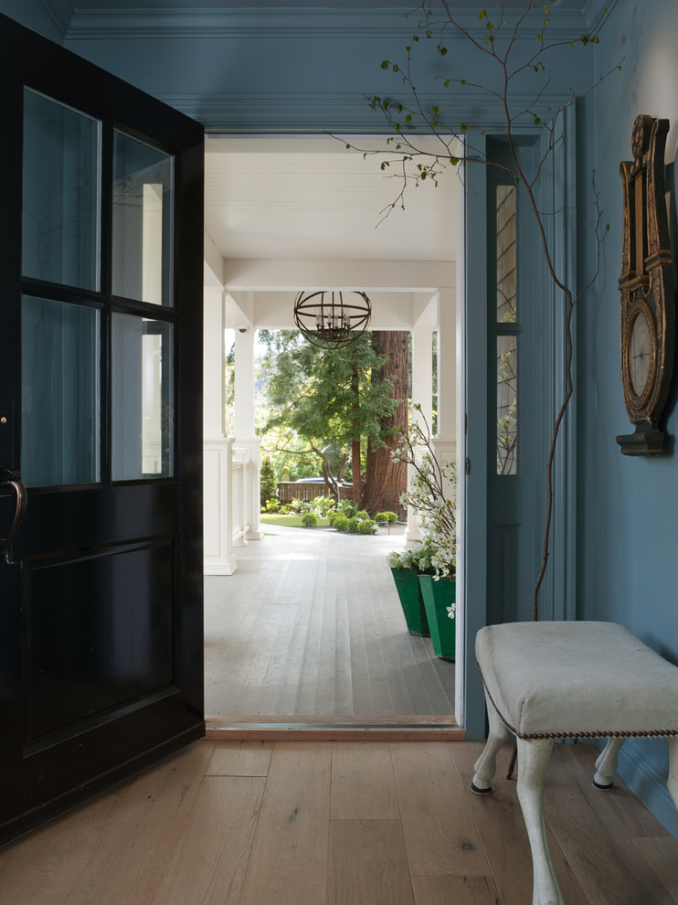 Example of a classic beige floor entryway design in San Francisco with a black front door and blue walls