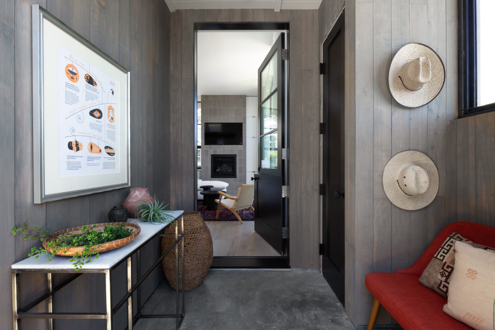 Inspiration pour un vestibule design de taille moyenne avec un mur gris, une porte simple, une porte noire et un sol gris.
