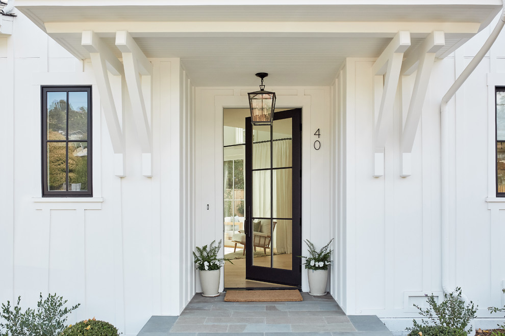 Klassische Haustür mit weißer Wandfarbe, Einzeltür, Haustür aus Glas und grauem Boden in Los Angeles