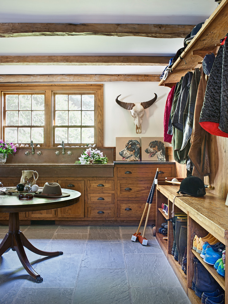 Photo of a farmhouse boot room in New York with white walls and slate flooring.