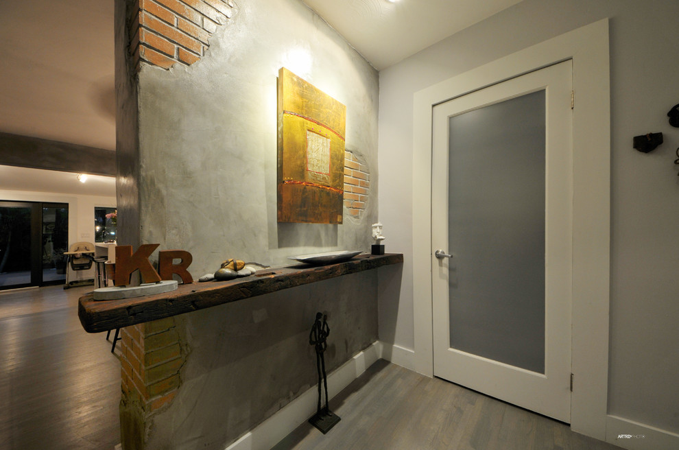 Example of a small trendy medium tone wood floor entryway design in Miami with gray walls and a brown front door