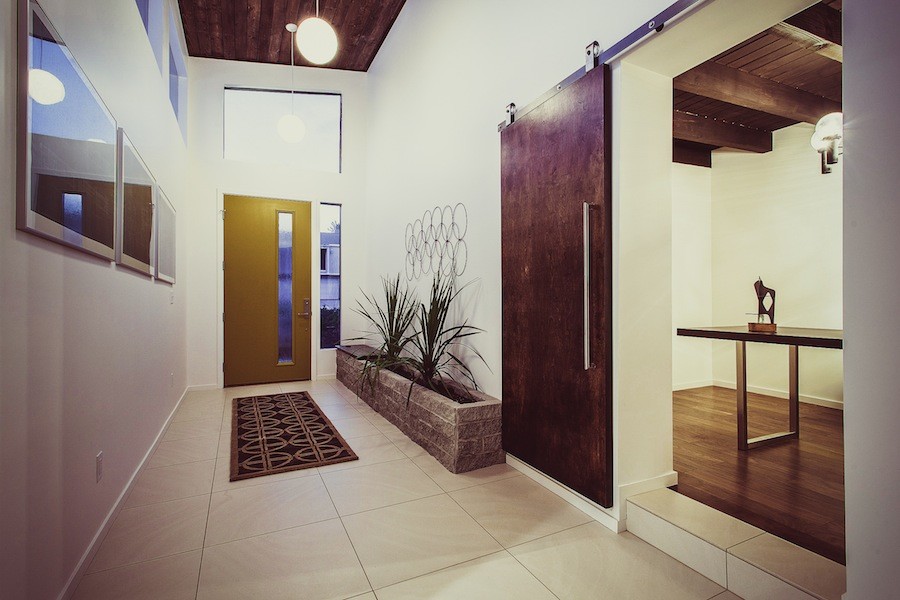 Immagine di un ingresso minimalista con pareti bianche, una porta singola, una porta gialla e soffitto in legno