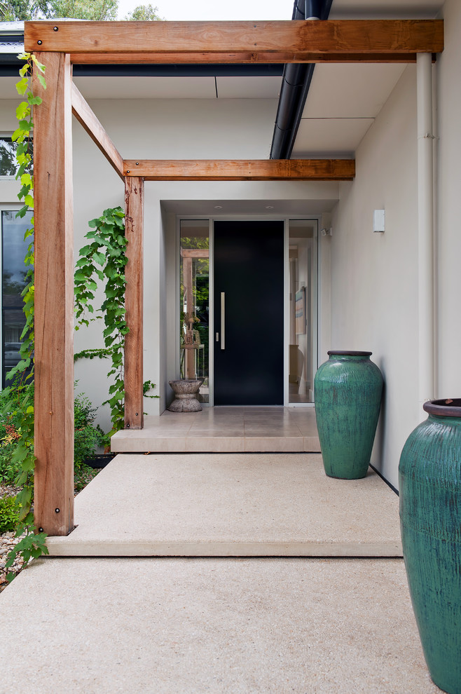 Mittelgroße Haustür mit Drehtür, schwarzer Haustür, Travertin und beiger Wandfarbe in Adelaide