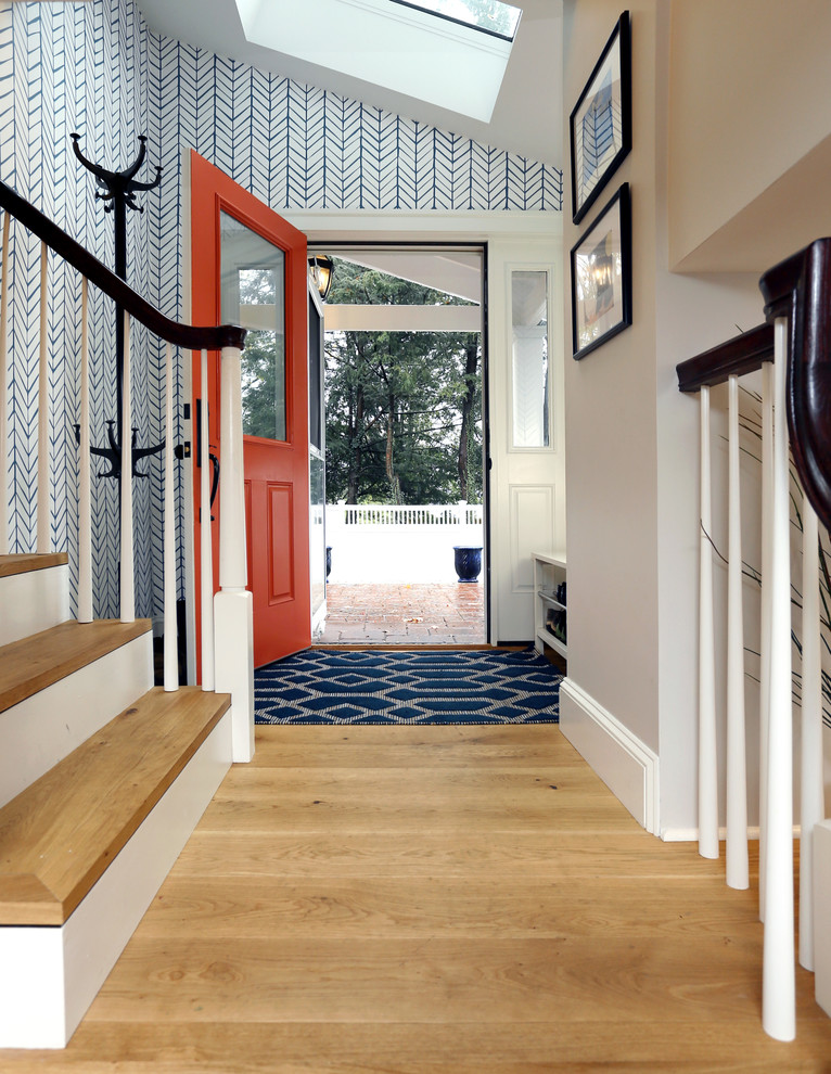 Idée de décoration pour une entrée tradition de taille moyenne avec un vestiaire, un mur bleu, parquet clair, une porte simple et une porte rouge.